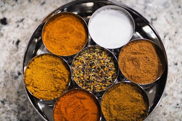 Various colorful spices arranged in metal bowls