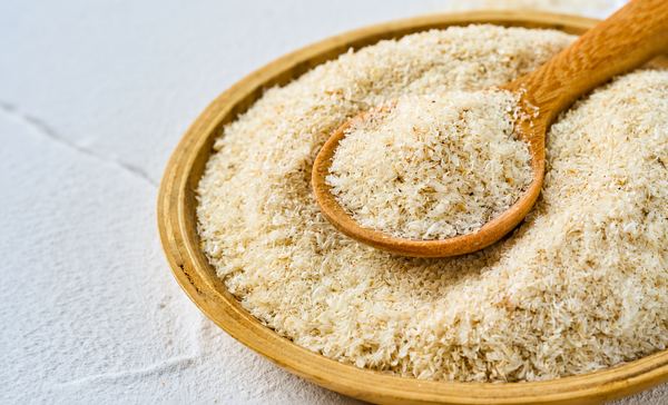 Fine white psyllium husk powder on a wooden surface