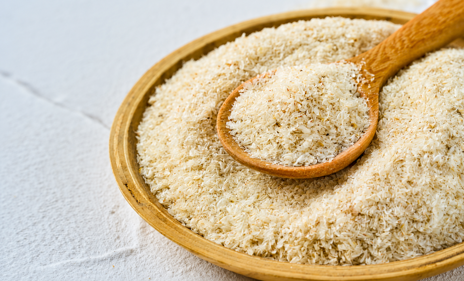 Fine white psyllium husk powder on a wooden surface